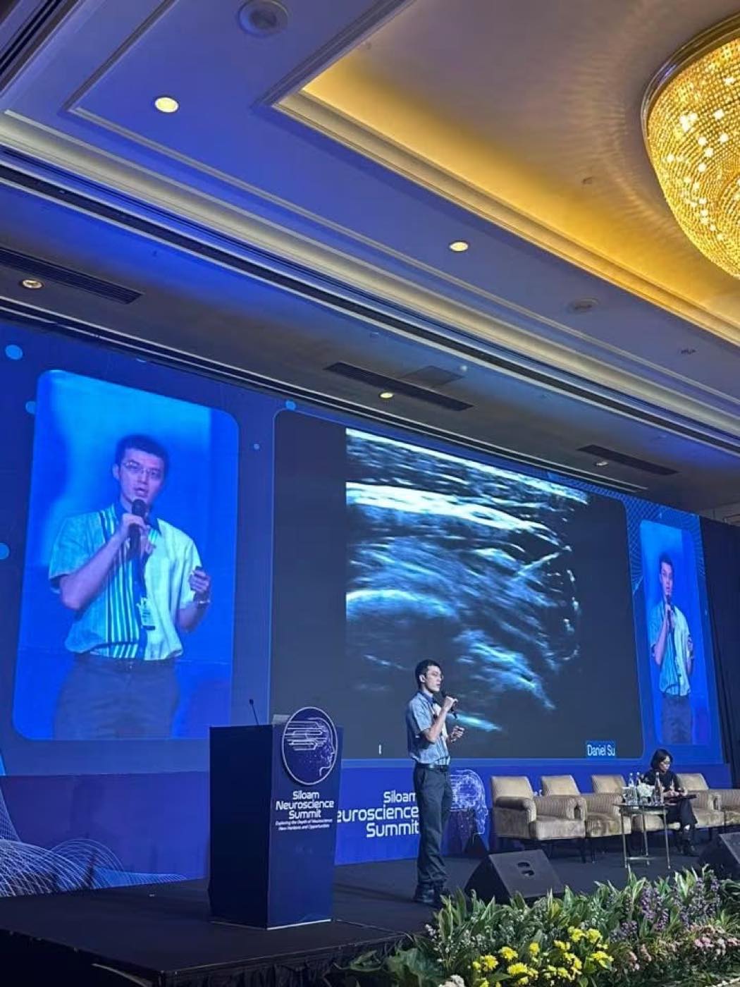 蘇炯睿醫師於印尼 Siloam Neuroscience Summit 演講，螢幕顯示超音波影像