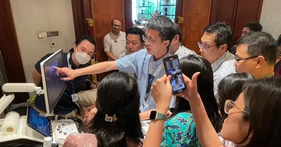 蘇炯睿醫師於海外醫學會工作坊示範超音波導引診斷，多位外國醫師圍在超音波儀器旁觀看與拍攝